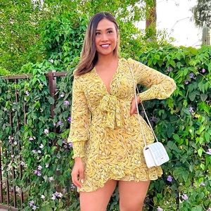 Short, long-sleeved yellow dress with a pattern.